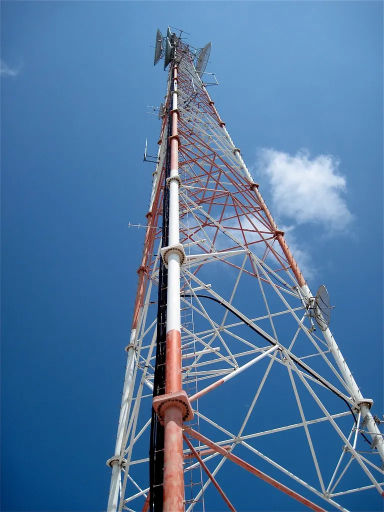 Mobile phone tower against a blue sky — the 3G services older alarm communicators relied on have been switched off